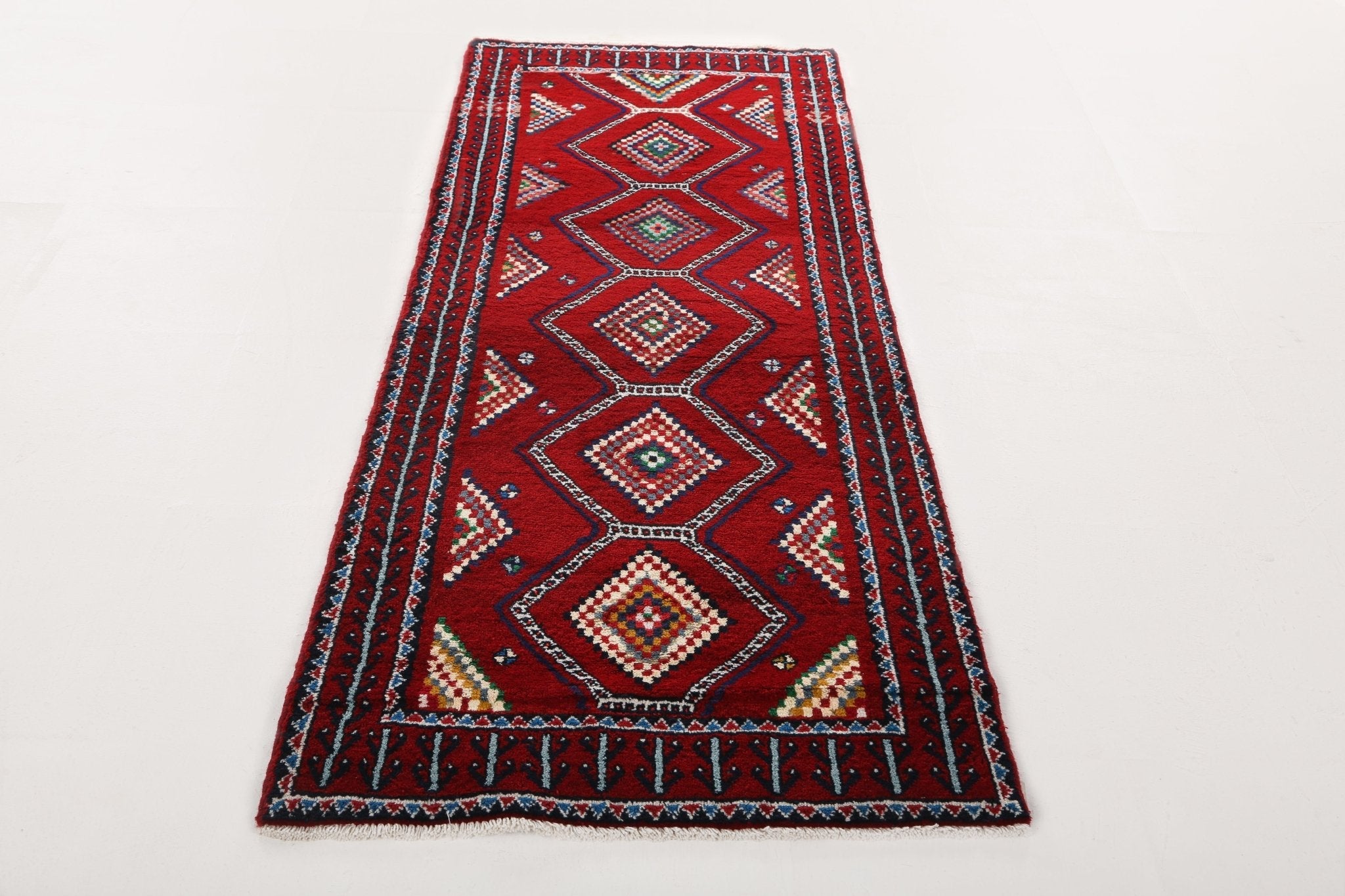 Persian Baluch runner rug with symmetrical red medallions and diamond lattice design