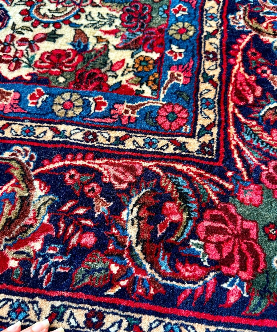 Bidjar-style rug corner detail with blue trim, red accents, and cream ornamental border