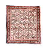 Persian Bidjar rug with cream field, red border, and multicolor geometric medallions.