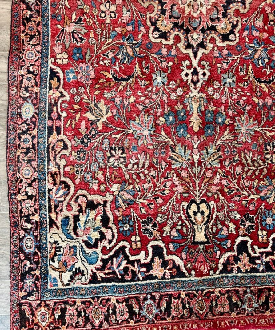 Red Persian Bidjar rug with navy border, floral medallion and detailed motifs.