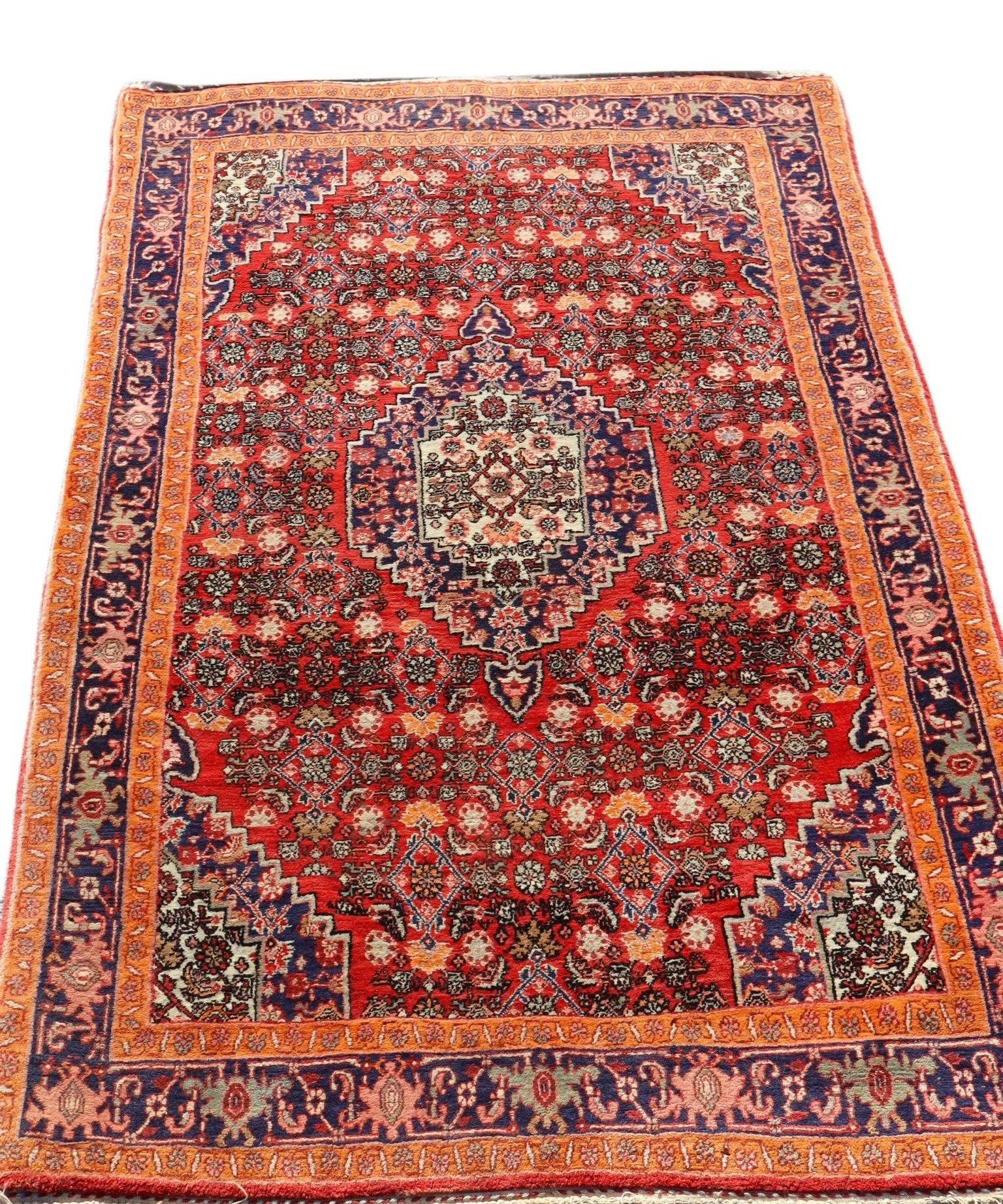 Persian Bijar rug with red center, navy corner accents, and blue border stripes