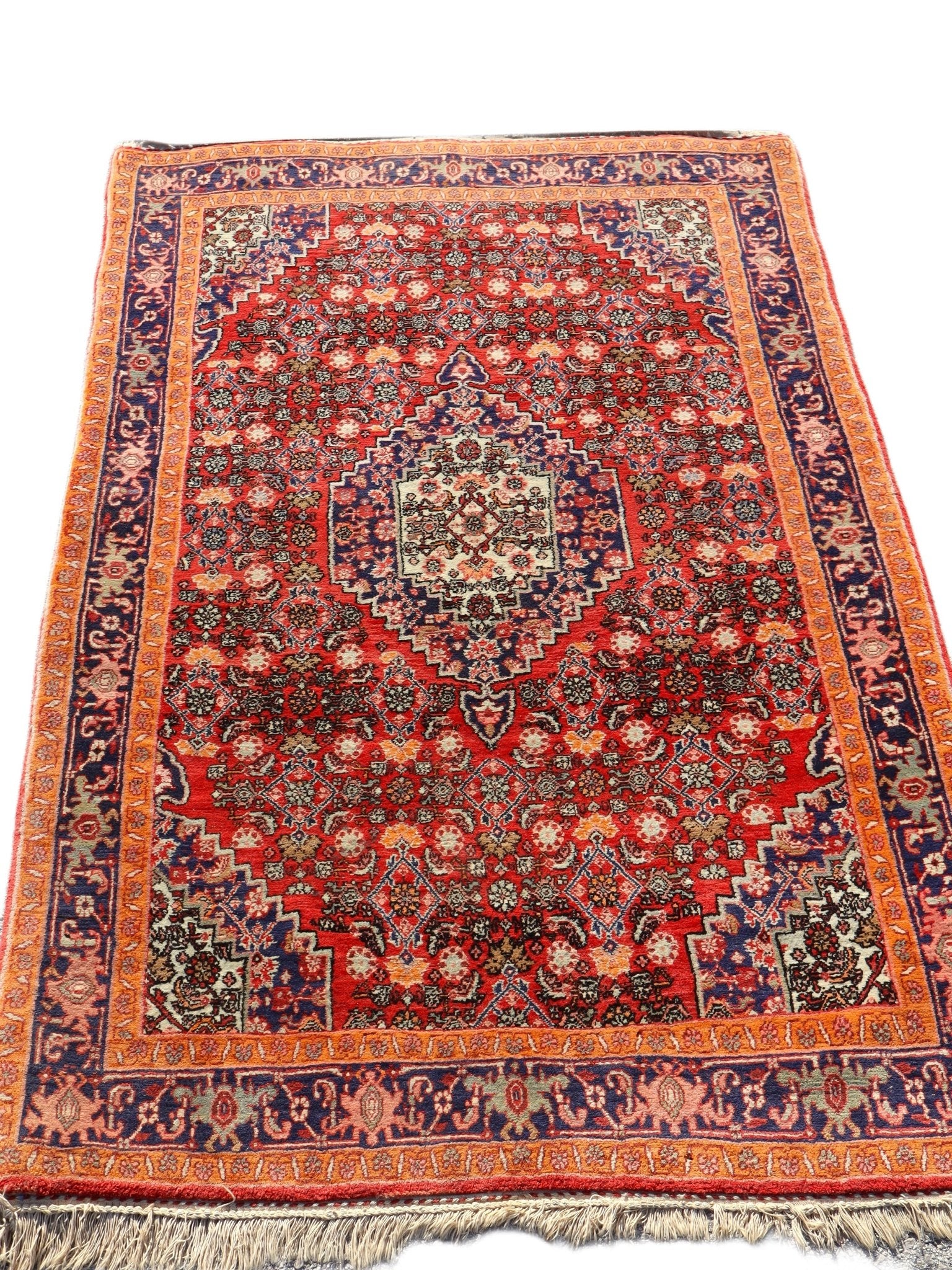 Persian Bijar rug with red center, navy corner accents, and blue border stripes