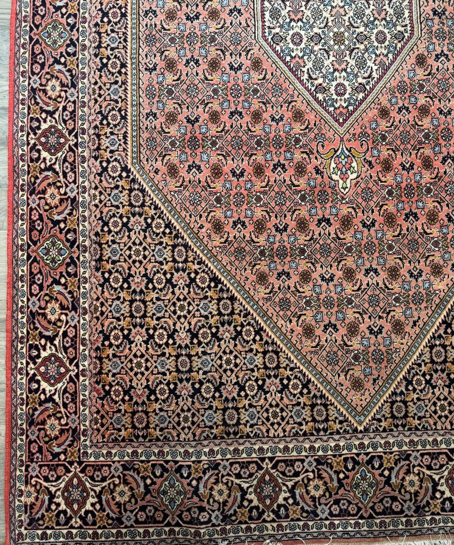 Persian rug with red field, teal and cream borders, geometric medallion, fringe ends