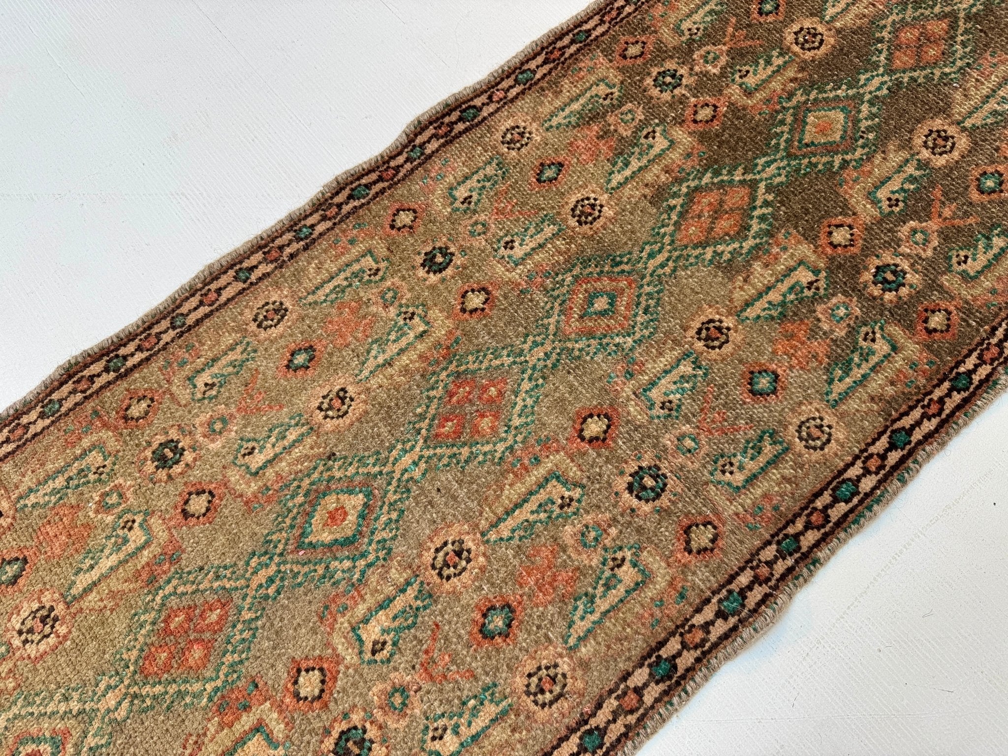 Persian Borujerd runner rug close-up of teal, orange and beige geometric motifs