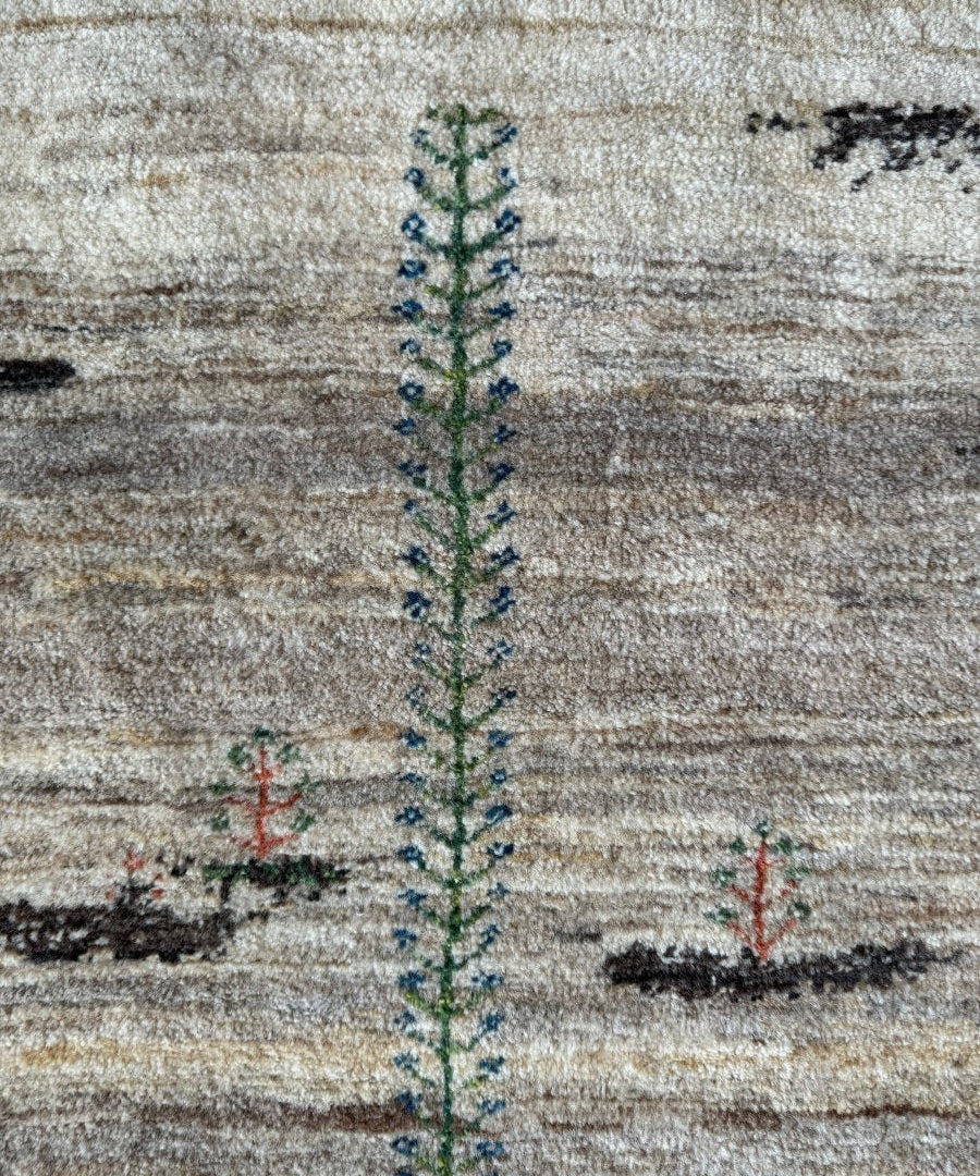 Persian Gabbeh rug close-up: beige weave with blue-green vertical ornament and red accents