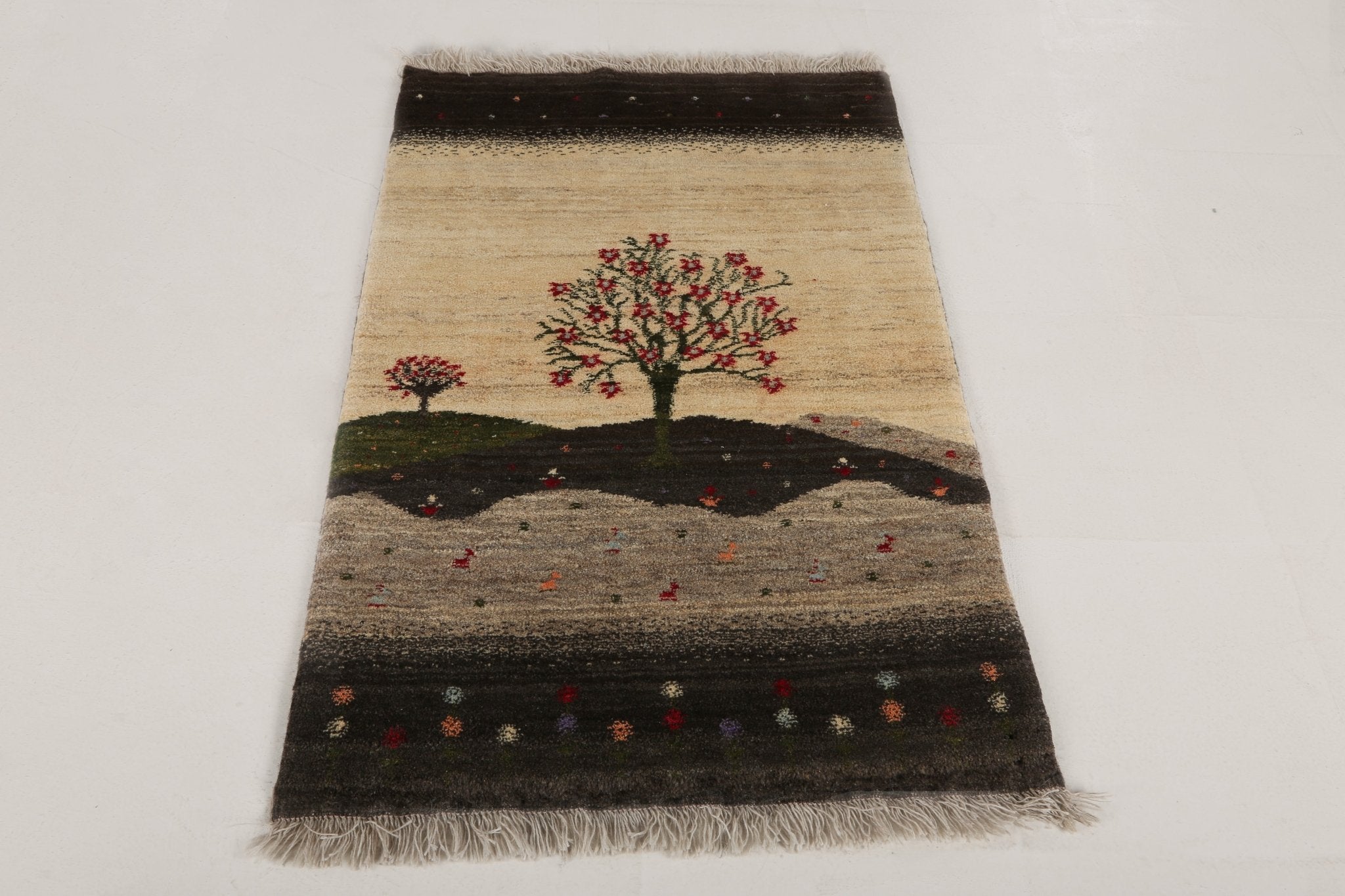 Persian Gabbeh rug featuring central tree on cream, dark striping, red details, fringe