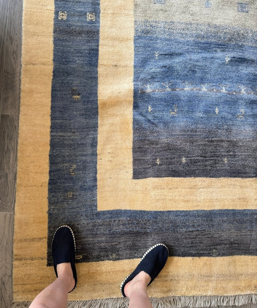 Gabbeh-style rug with blue-gray center, beige borders, flat weave and short fringe