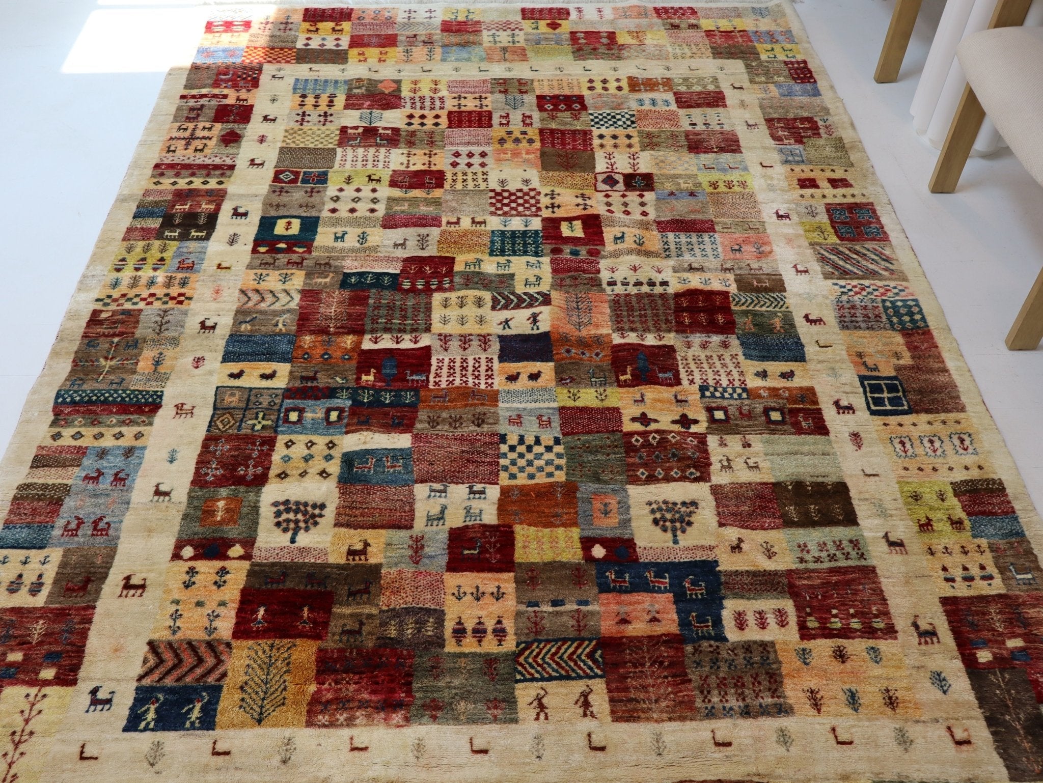 Persian Gabbeh-style rug with multicolor geometric patchwork blocks on light ground