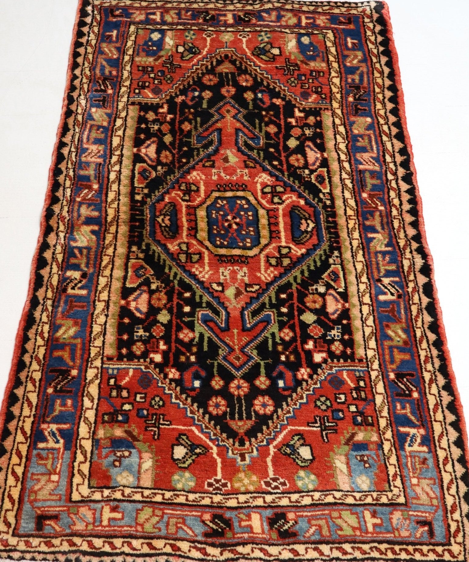 Persian Hamadan rug full view with red, black, and cream geometric medallions
