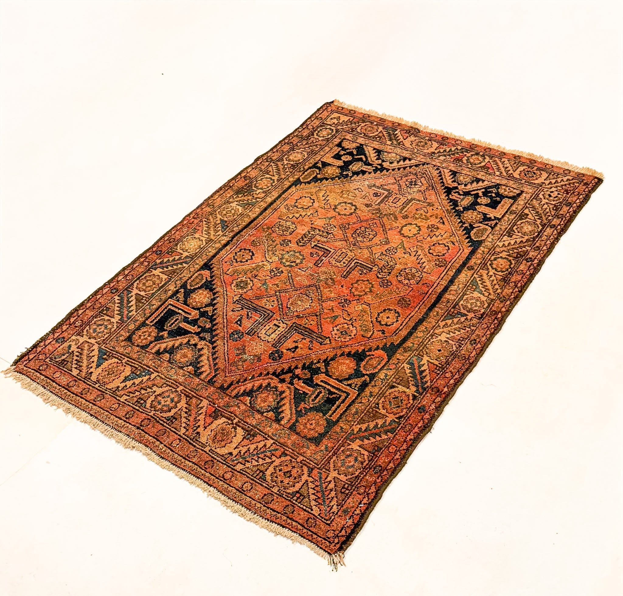 Hamadan rug with rust orange and dark blue central diamond motif, fringed corners