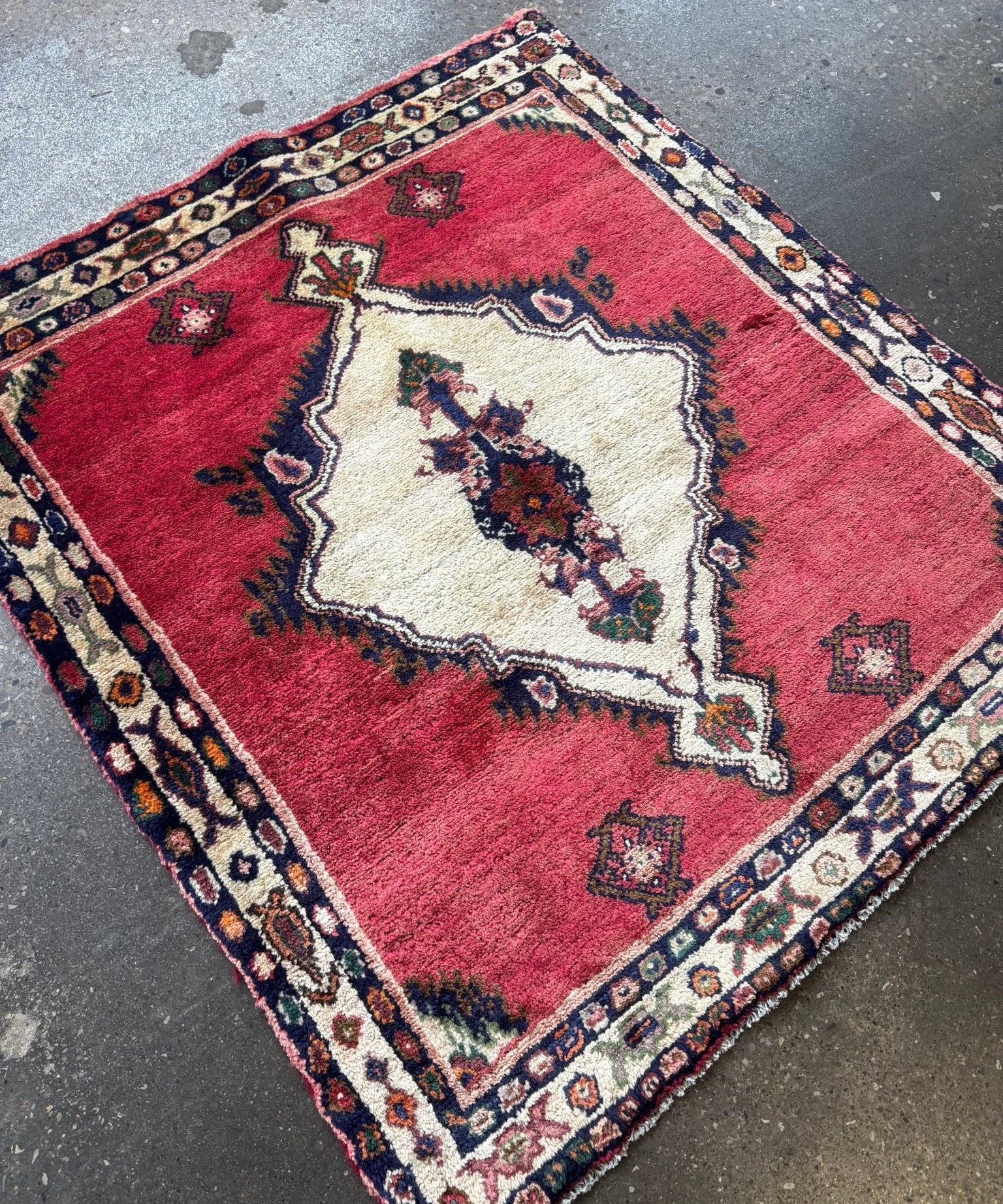 Small area rug, red with cream geometric center and patterned navy trim