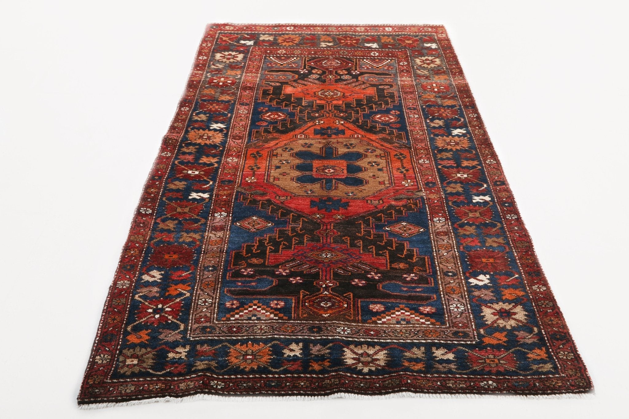 Persian Qoltuq area rug with red border, navy accents, and central medallion