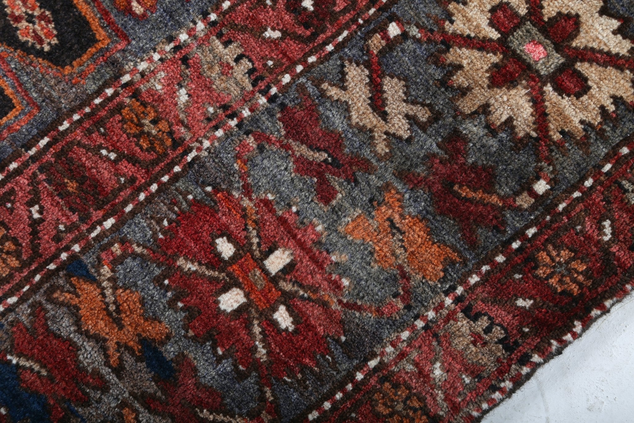 Persian Qoltuq rug close-up with gray field, red florals, and navy accents