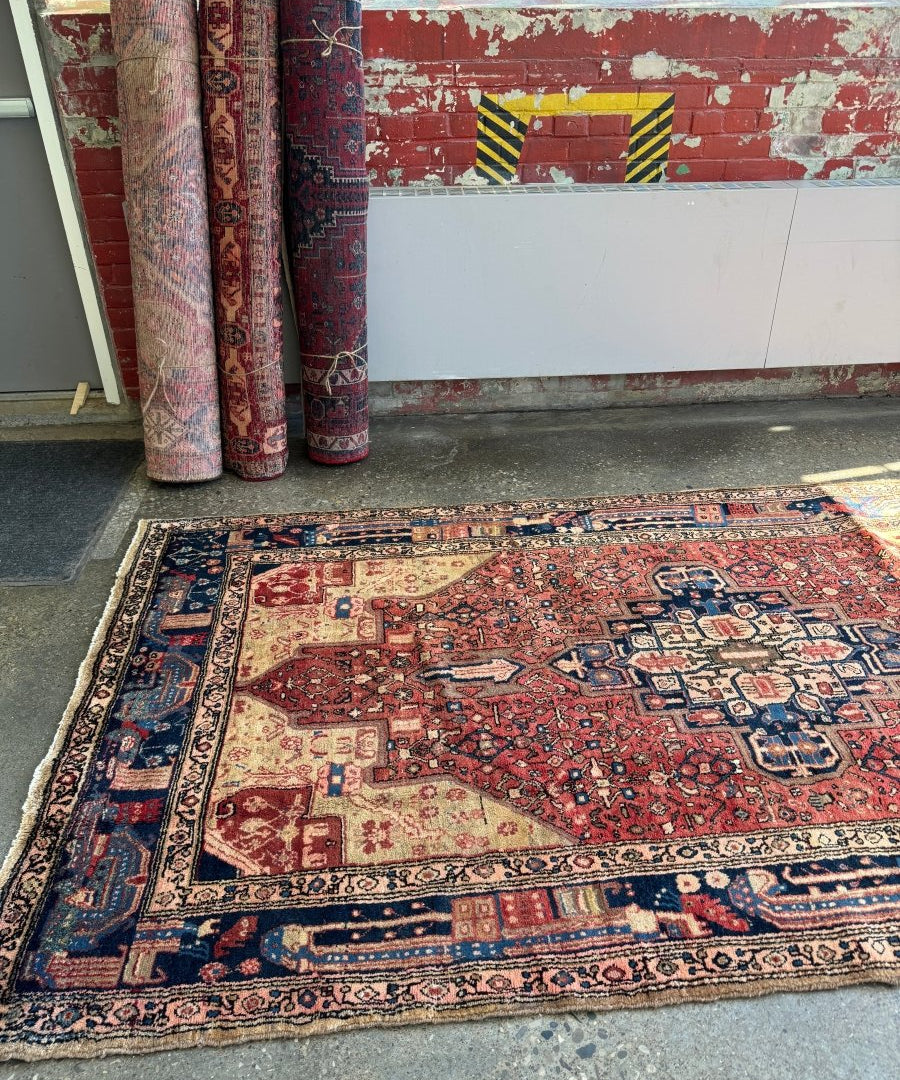 Persian-style Hamadan rug, red field with medallion and patterned navy border