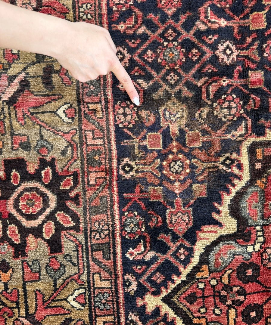 Close-up of Persian rug border with navy, red, ivory geometric motifs