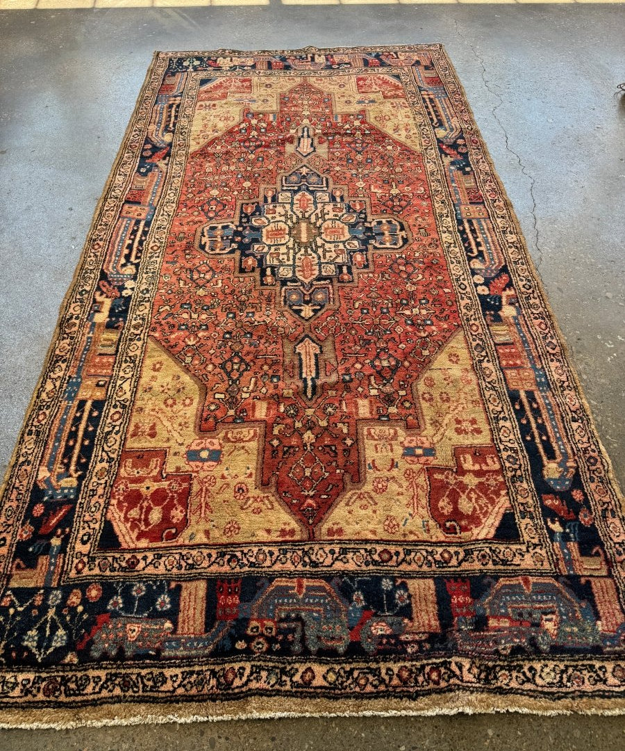 Persian-style Hamadan rug with red central medallion and navy border, cream accents