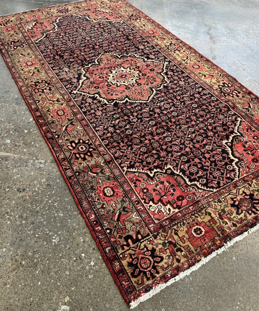 Hamadan-style Persian rug with navy field, red medallion, and detailed border