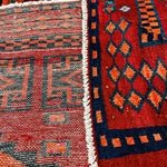 Close-up of rug fringe and side design: white band border with navy and red motifs.