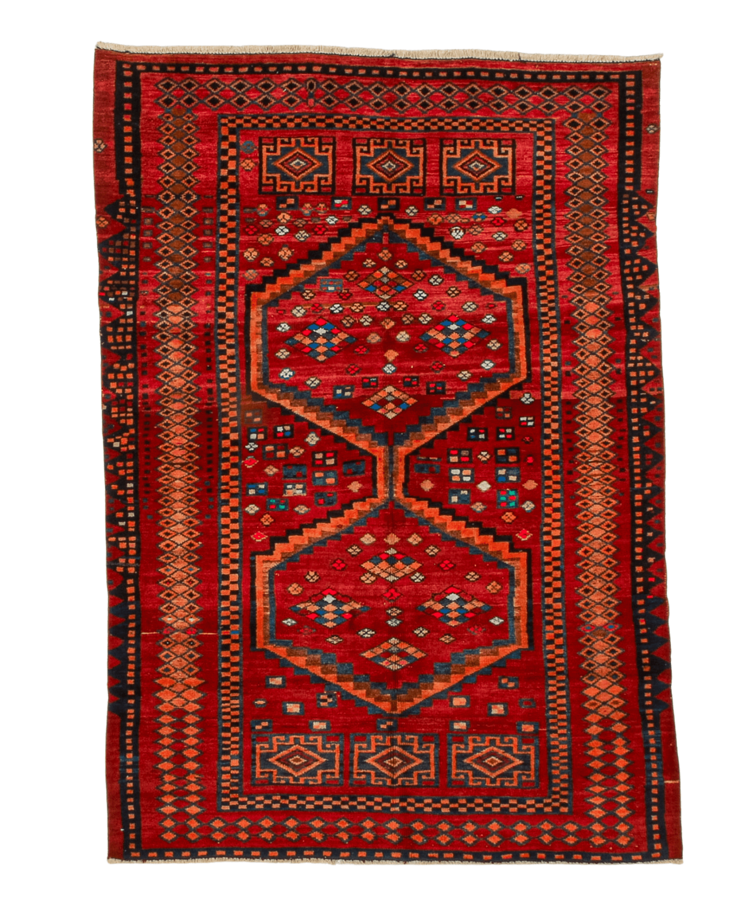 Red area rug with navy and orange stepped medallion pattern and cream fringe on edges.