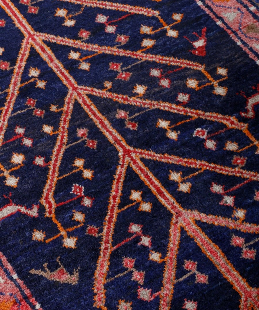 Close-up of navy runner rug pattern with diagonal orange lines and small motifs