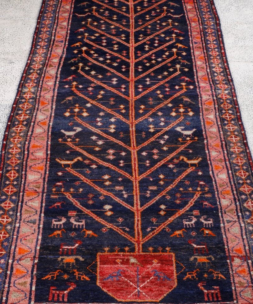 Navy Persian-style runner rug with red medallion and geometric orange accents