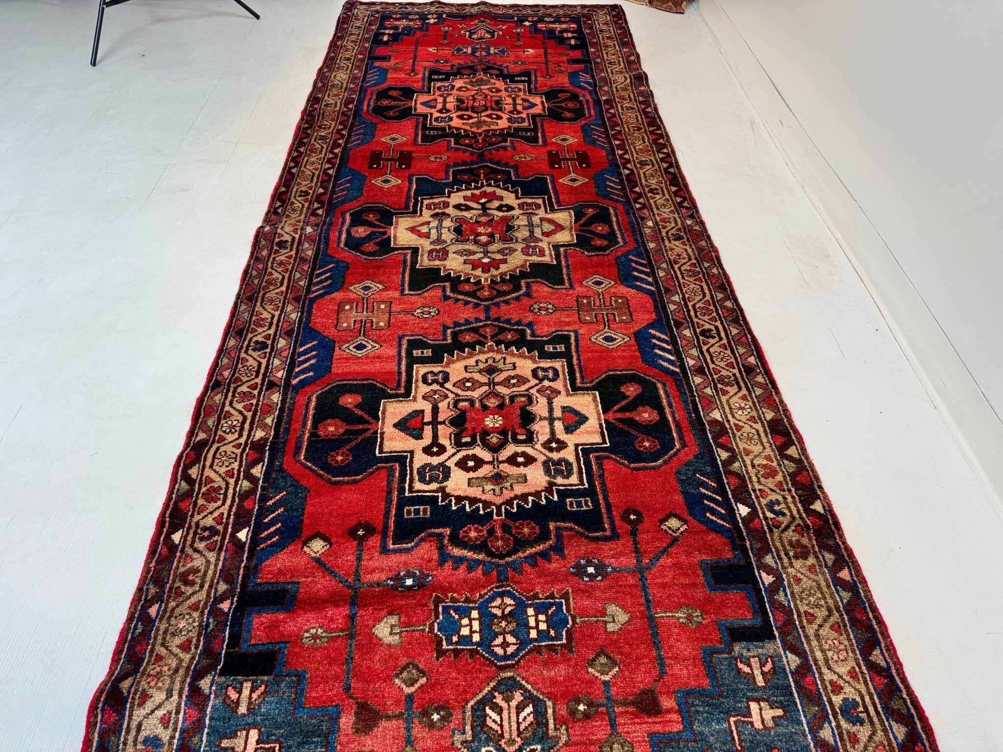Hamadan runner rug with red field, navy accents, and ornate central medallion