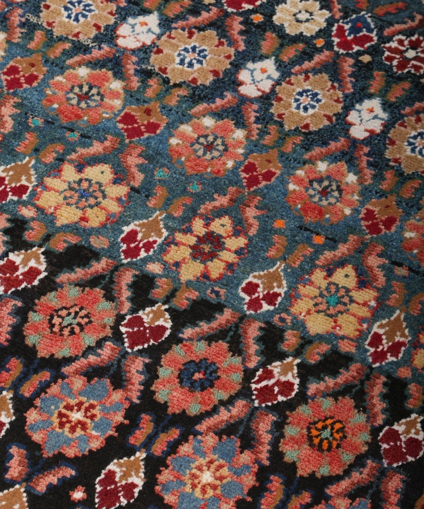 Persian Hamadan runner rug close-up showing scattered floral motifs on dark blue