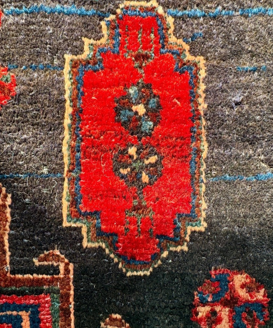 Close-up of Persian-style rug motif in bright red with navy and green accents