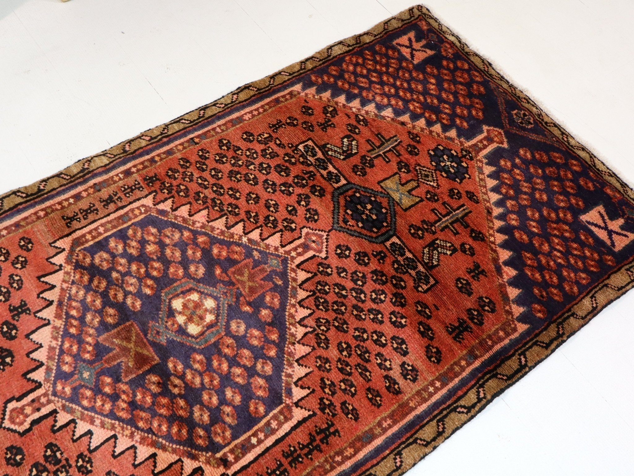 Persian Hamedan-style rug with rust red, navy, and cream geometric medallion pattern
