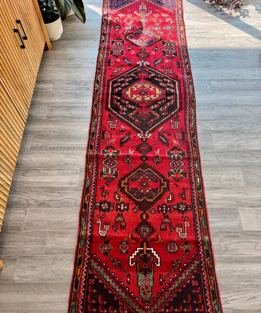 Red Persian Hamedan runner rug with central medallion and repeating border motifs