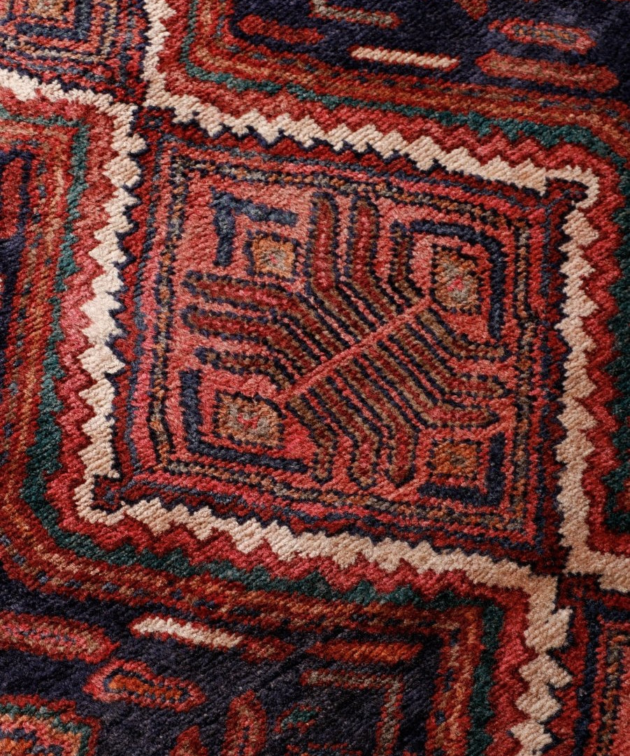 Close-up of Persian Hamadan runner rug pattern with rust, cream, and teal accents