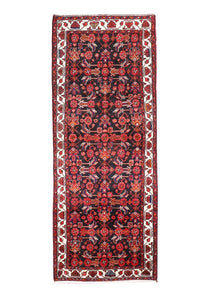 Persian runner rug with dark red medallion pattern, black field, cream border stripes