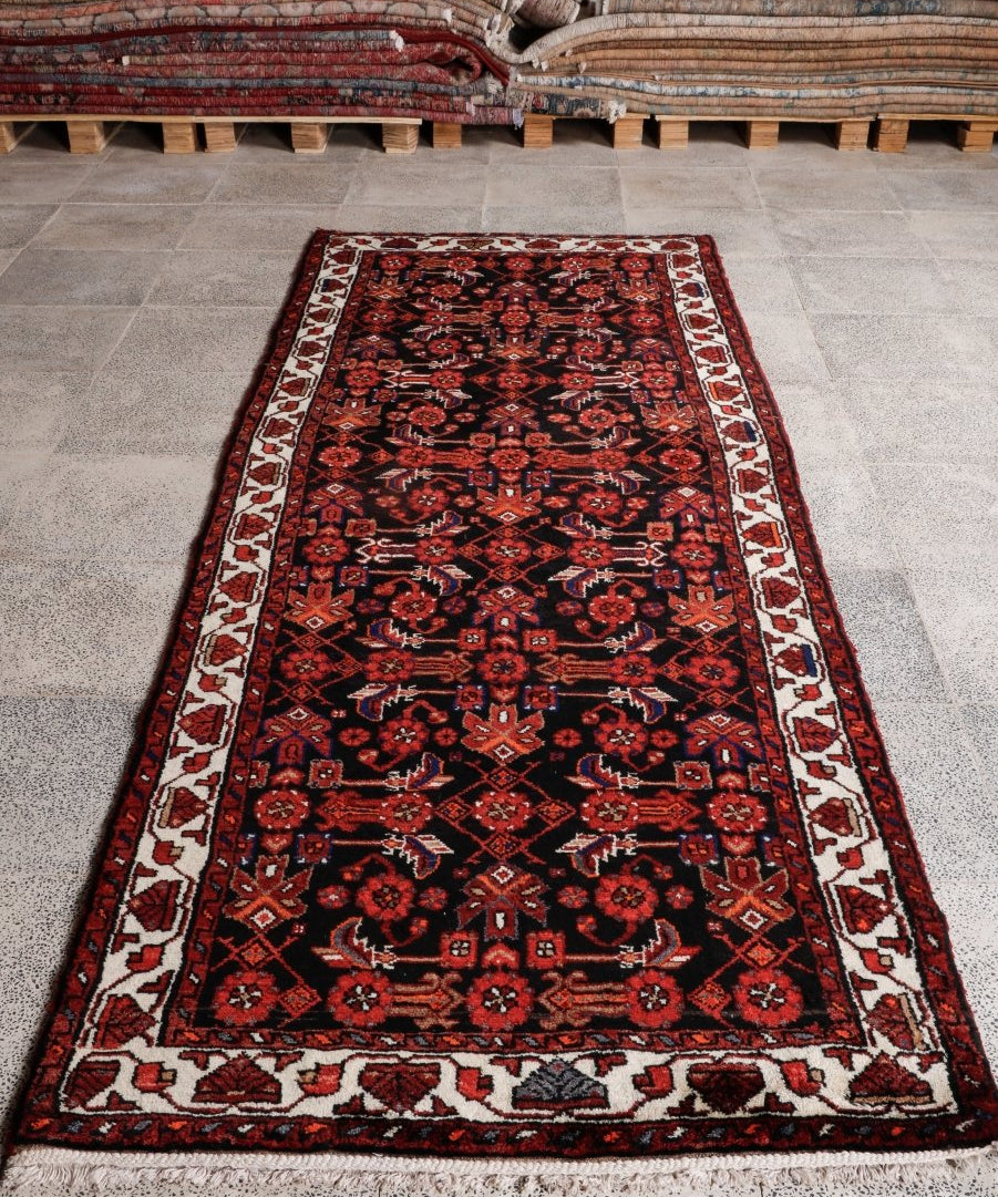 Persian runner rug, dark red and black geometric motif with cream and navy border details