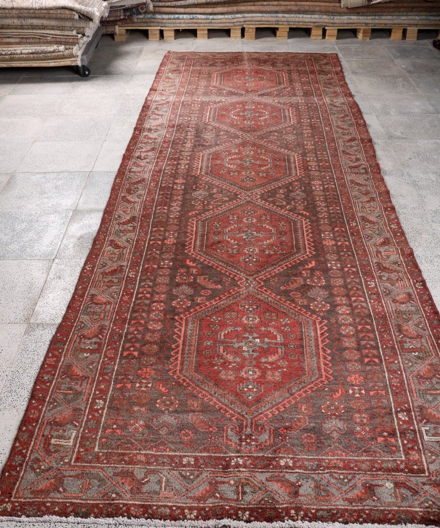 Persian Hamedan runner rug, red with repeating medallion motifs and detailed patterned border.