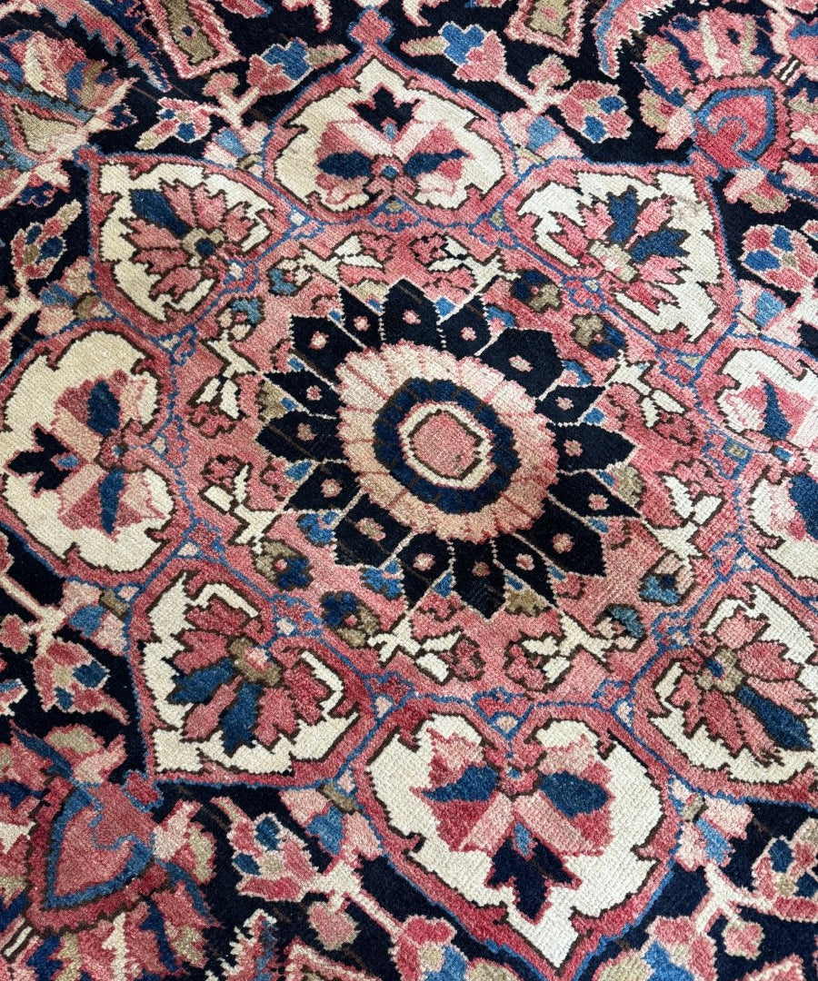 Persian Heriz rug detail with floral motifs and navy, red, and cream accents