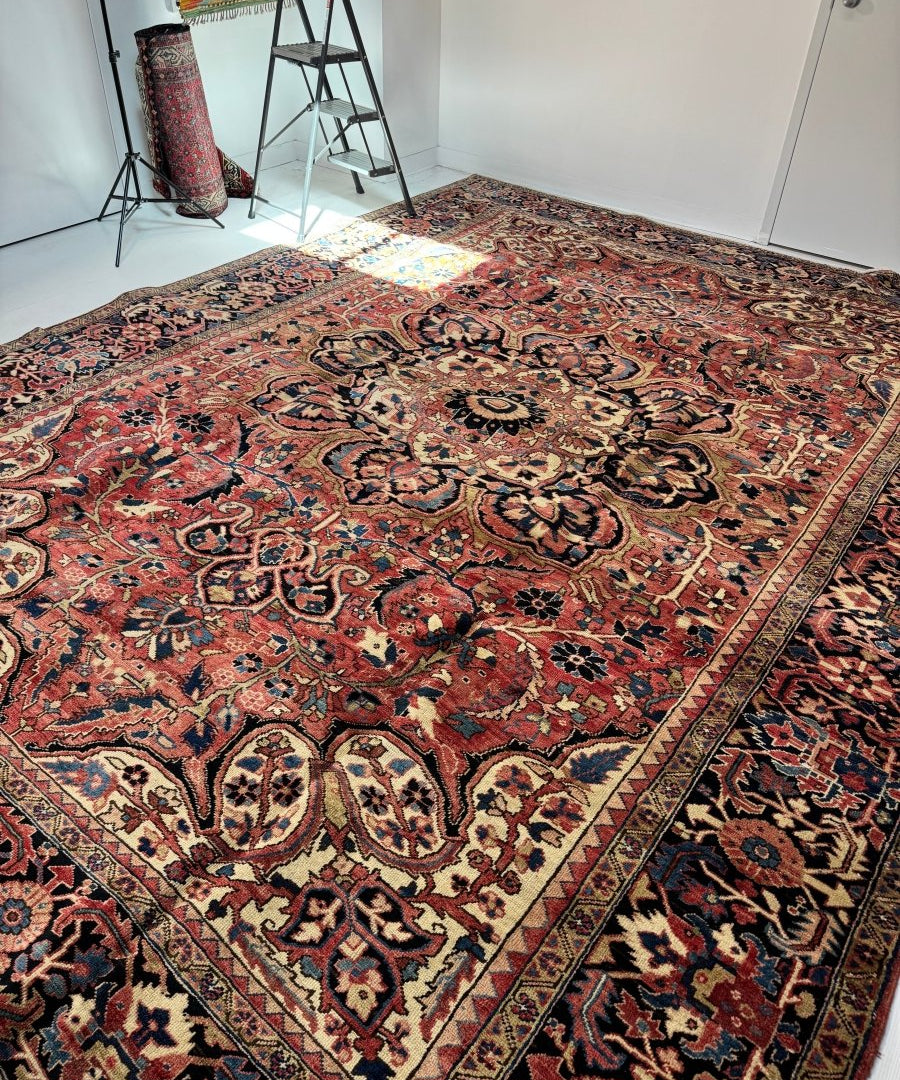 Persian Heriz rug with ornate medallion design in red, navy, and cream tones