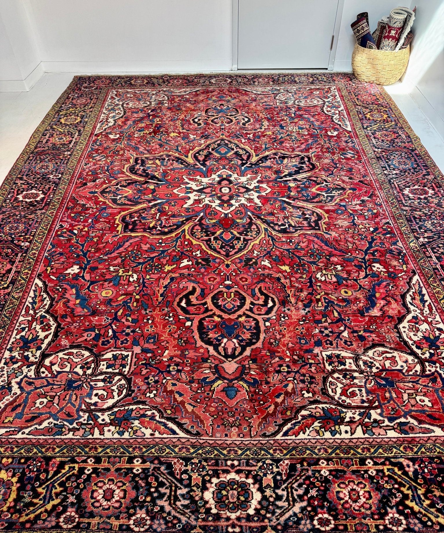 Persian Heriz rug with red field, blue and cream medallions, ornate border pattern