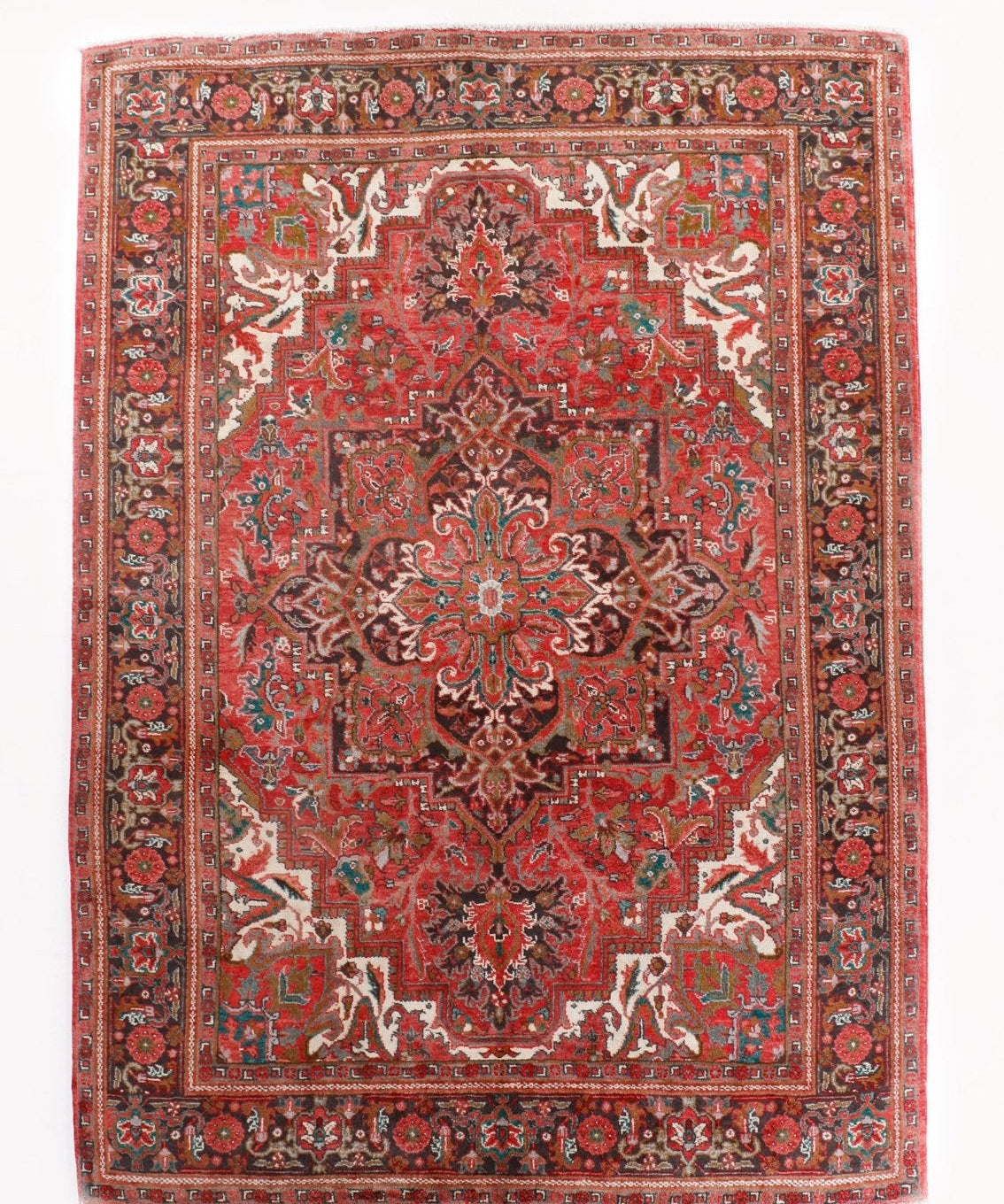 Persian Heriz rug with red medallion center, teal and cream details, ornate border.