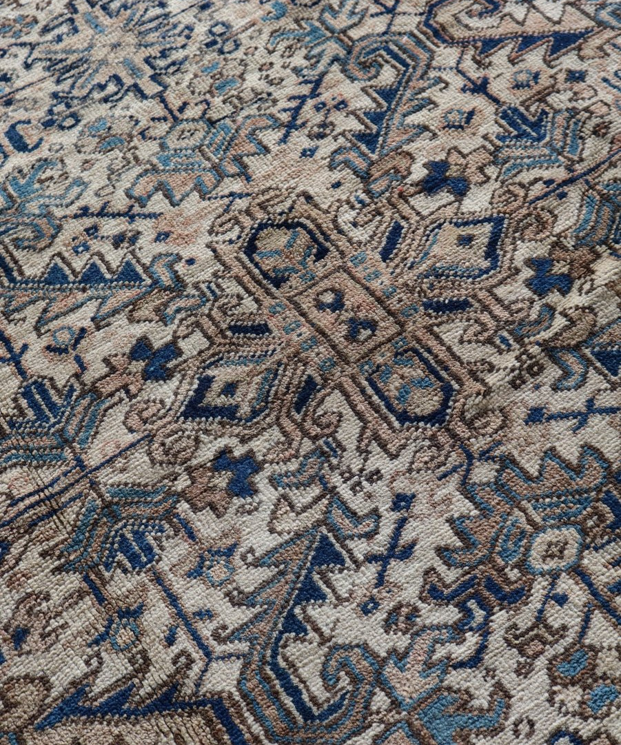 Heriz rug close-up with blue-on-cream medallion and repeating diamond motifs