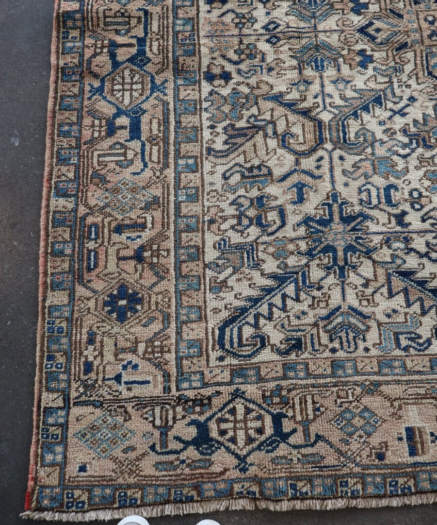 Persian Heriz rug with blue and cream geometric border and short fringe edges