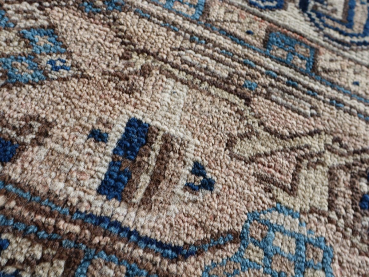 Heriz rug pile close-up in cream with small blue diamond details and border stripe