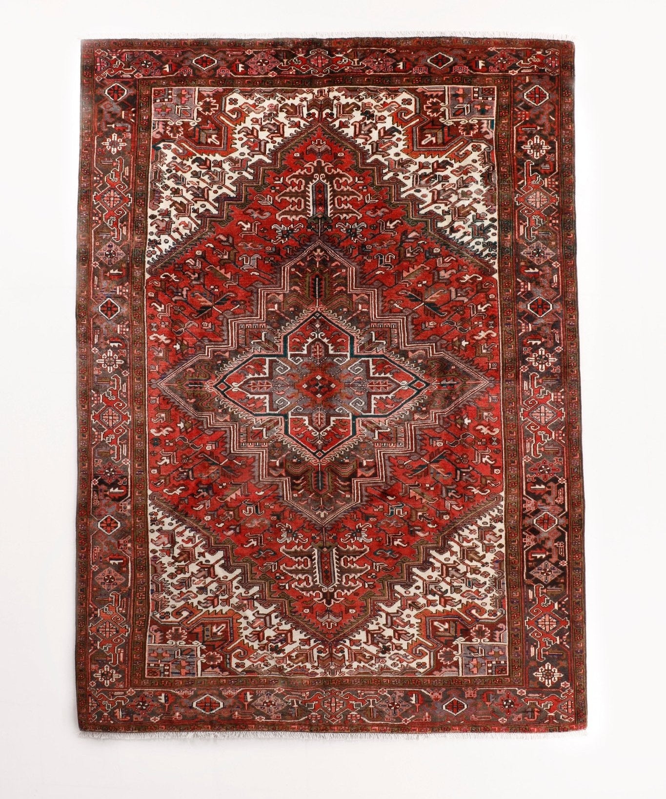 Persian Heriz rug with red, rust, cream geometric medallion and navy border.