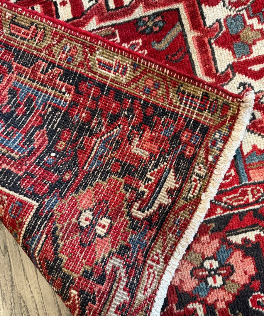 Close-up of red, navy, and cream Persian rug corner with textured fringe
