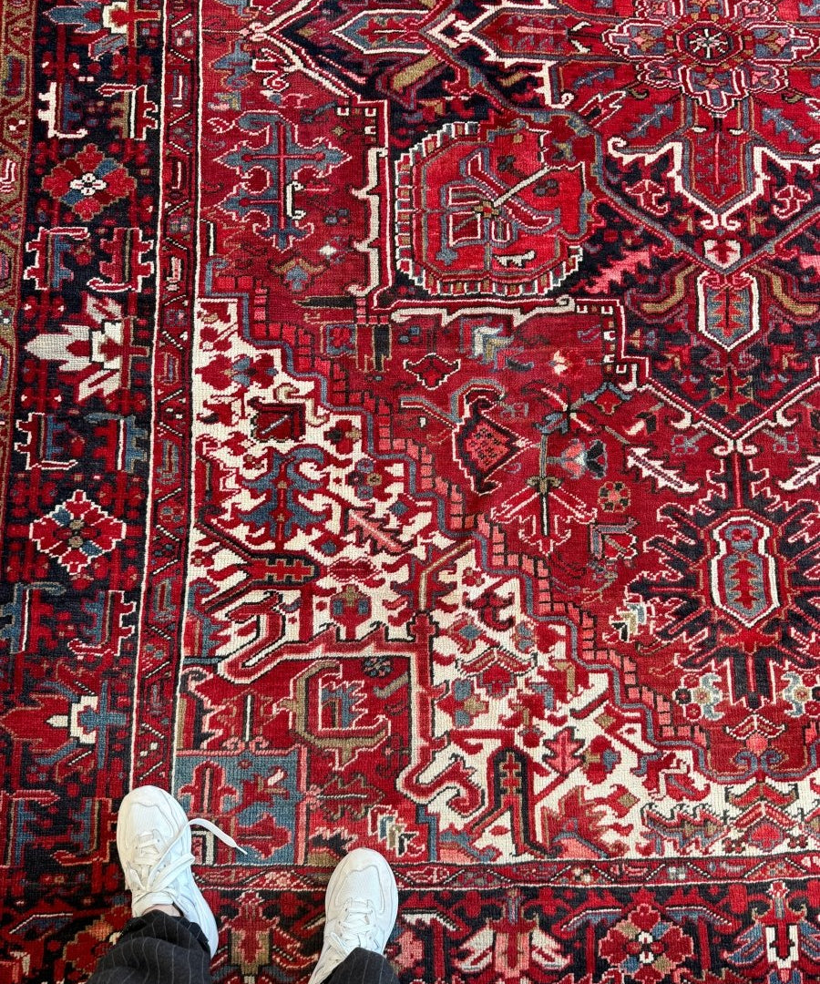Red and navy Persian rug with cream geometric medallions and ornate border