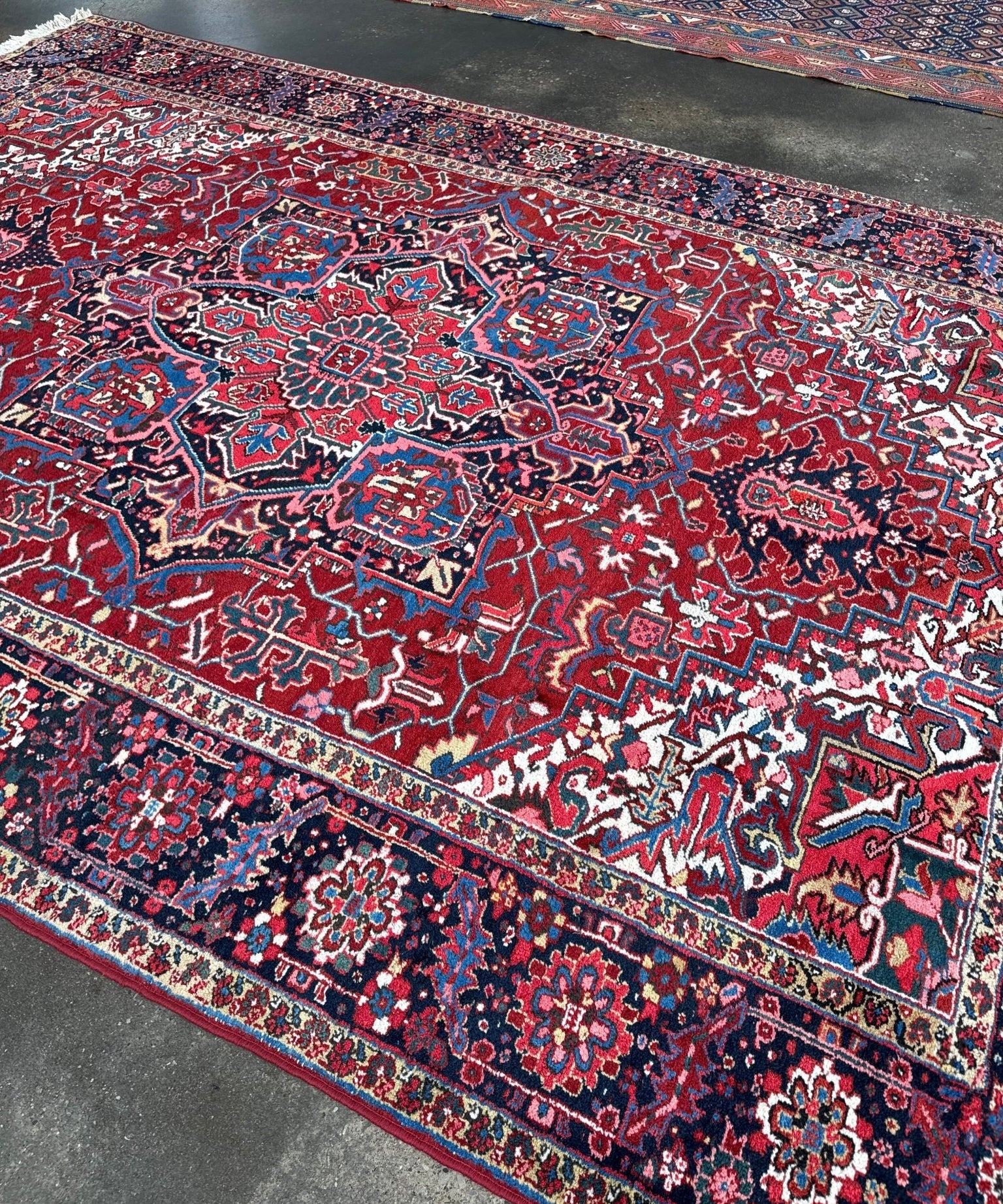 Red and navy Persian-style area rug with central medallion and decorative borders.