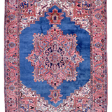 Persian Heriz rug, red and blue with central medallion, ornate geometric border.
