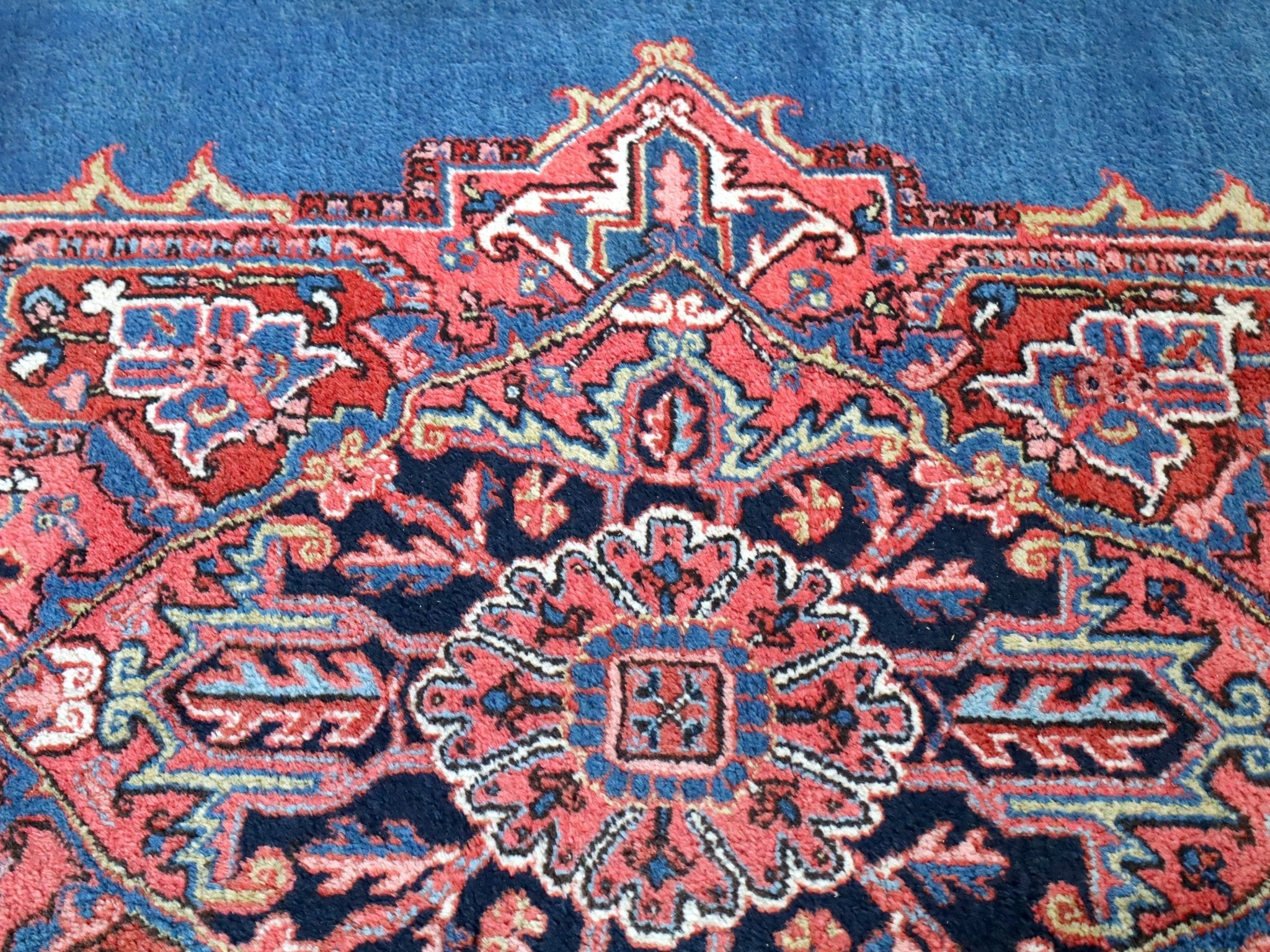 Persian Heriz rug central medallion detail with red, cream, and blue interlocking shapes