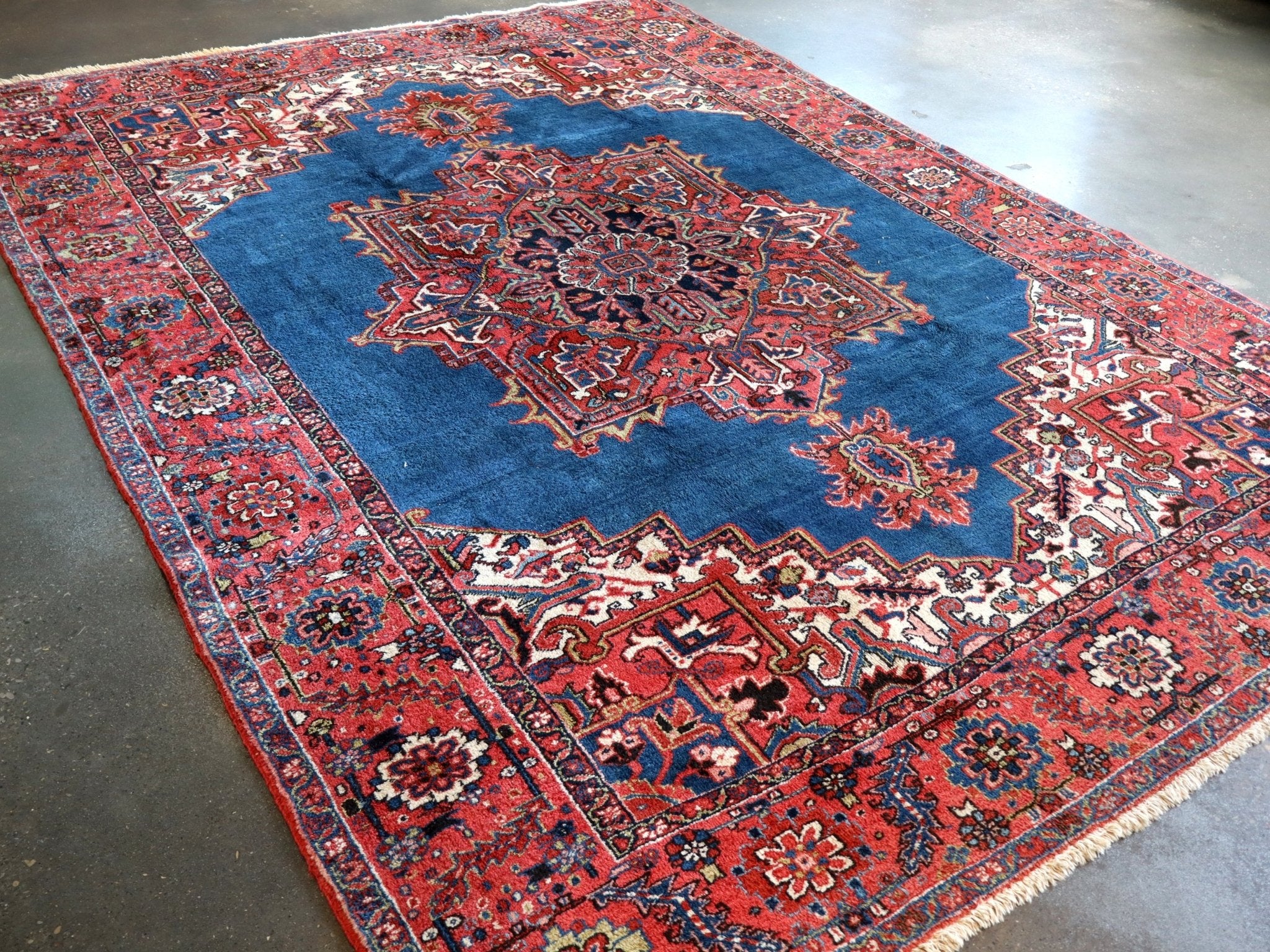 Persian Heriz rug close view with blue field, red patterns, and detailed border edging