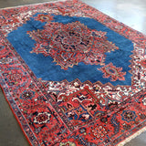 Persian Heriz rug close view with blue field, red patterns, and detailed border edging