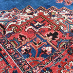Heriz rug detailed blue, red, and cream vine motifs, angled close-up